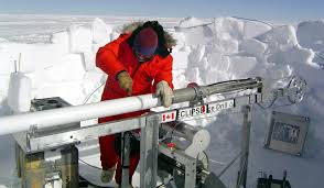 A scientist removing a freshly drilled core from an antarctic field site (NSIDC)